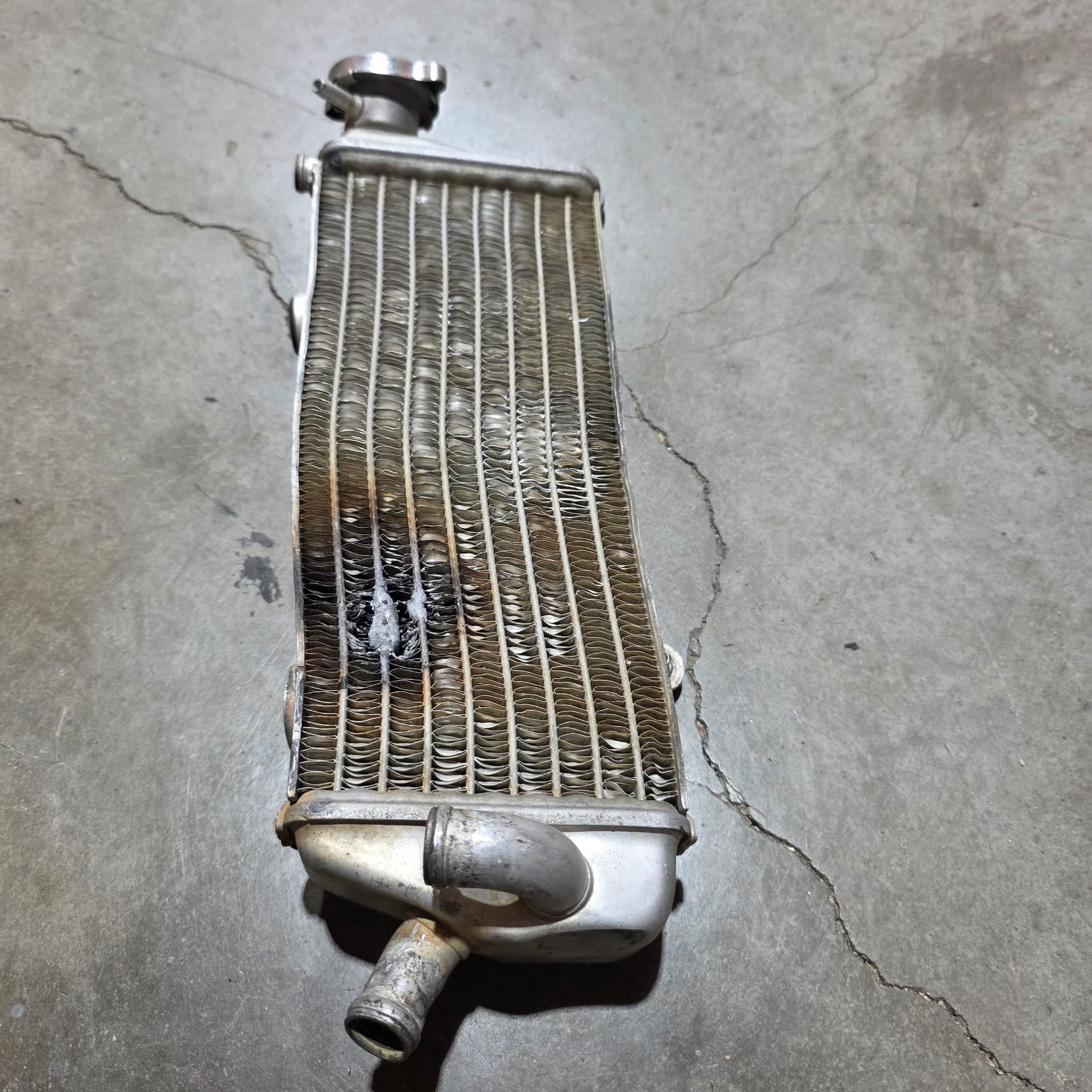 Radiador de moto de enduro roto y reparado